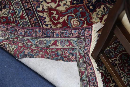 A Persian red and blue ground carpet. 9ft 10in by 7ft 2in.